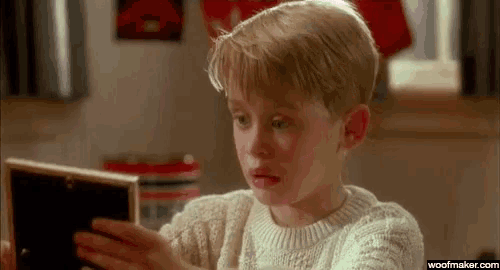 a young boy is looking at a picture frame in a room .