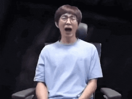a man in a blue shirt is sitting in a chair with his mouth open and his eyes closed .