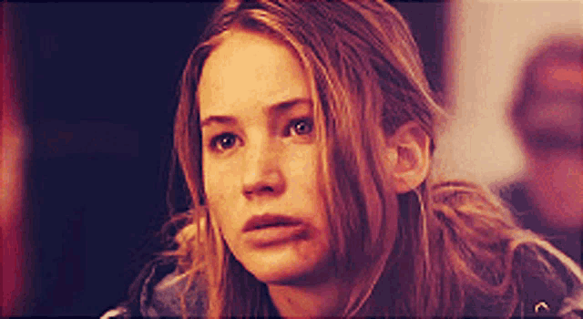 a close up of a woman 's face with a slight smirk on her face