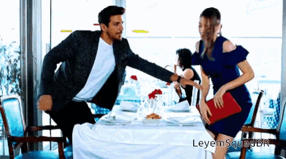 a man and a woman are dancing in a restaurant with leyemsquadbr written on the bottom right