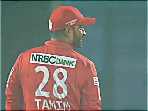 a man wearing a red nrbc bank shirt