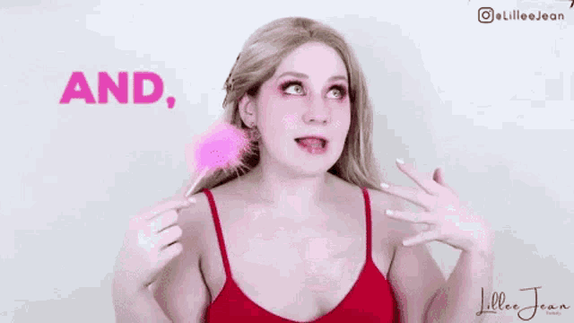 a woman in a red tank top is holding a pink lollipop and making a face .