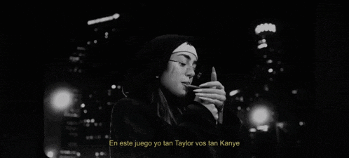 a woman is smoking a cigarette in a black and white photo with a caption in spanish .