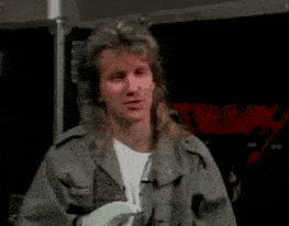 a man in a military jacket is holding a guitar in his hand .