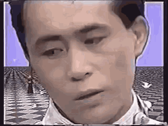 a man is making a funny face in front of a checkered floor .