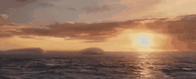 a sunset over a large body of water with mountains in the distance