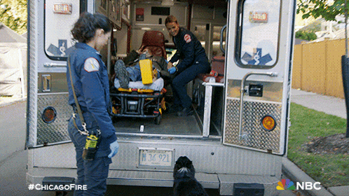 two female firefighters are standing next to an ambulance with a license plate that says m3x921