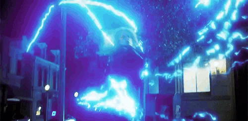 a blue lightning bolt is coming from the ceiling of a building in a city at night .
