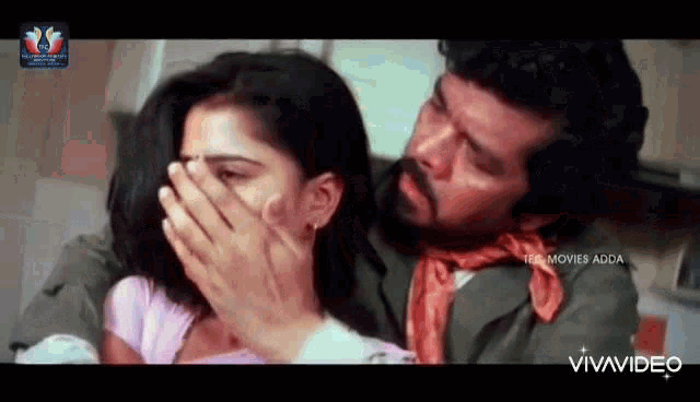 a man is covering a woman 's mouth with his hands in a movie .
