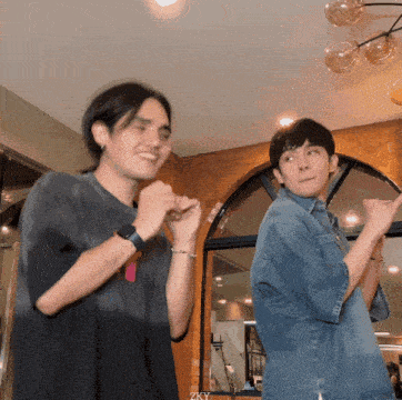 two men are standing next to each other with one wearing a watch and the other a denim shirt