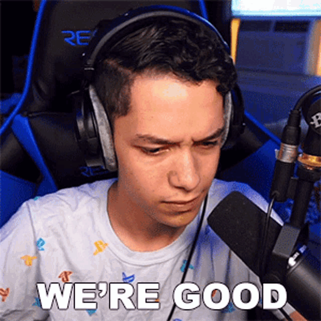 a man wearing headphones is sitting in front of a microphone and says " we 're good "