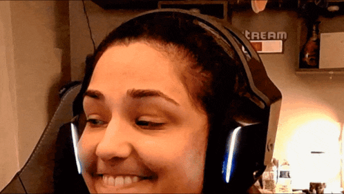 a woman wearing headphones with a stream sign in the background