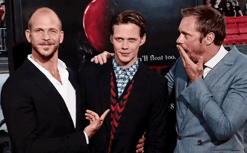 three men are standing next to each other in front of a poster that says ' i 'll float too '