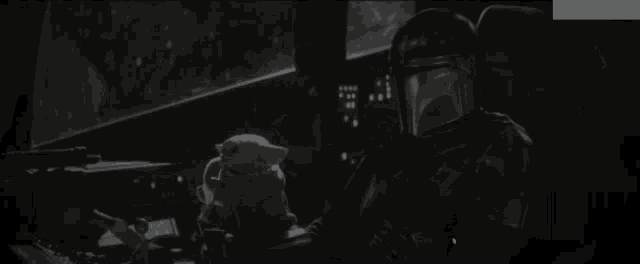 a baby yoda is sitting in a blanket in the dark .
