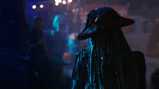 a woman with blue dreadlocks and a black hat