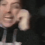 a man is talking on a cell phone and smiling .