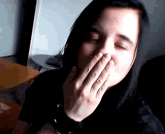 a woman covering her mouth with her hand while wearing a watch
