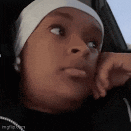 a woman wearing a headband is sitting in a car with her hand on her face .