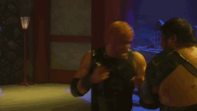 two men are fighting each other in a dark room