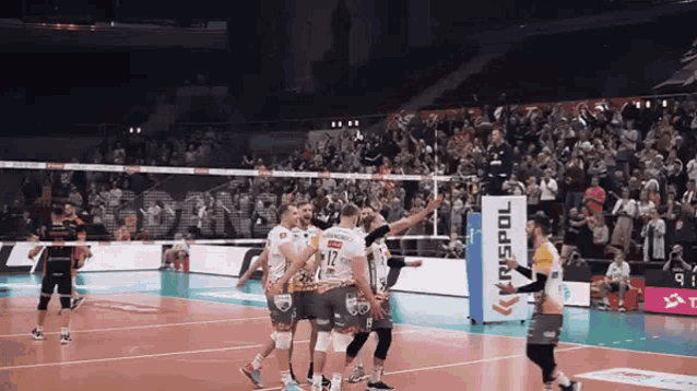 a volleyball game is being played in front of a sign that says rnspol