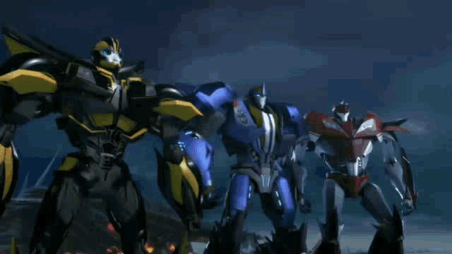 a group of transformers are standing next to each other in a dark room