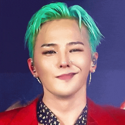 a man with green hair is wearing a red jacket and smiling