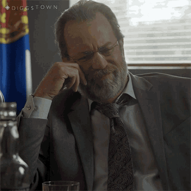 a man in a suit and tie is sitting in front of a flag with the hashtag diggstown