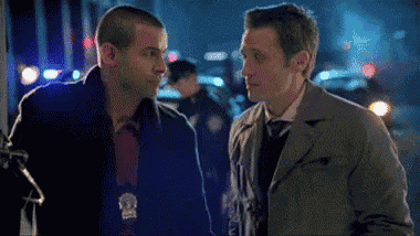 two men are standing next to each other and one has a badge on his chest that says police