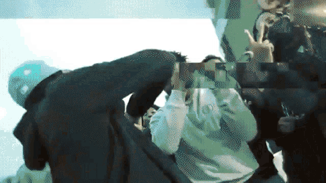 a person taking a picture of another person with a green background