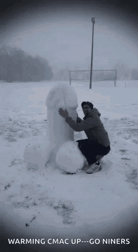 a man kneeling down next to a snowman with the words warming cmac up go niners below him