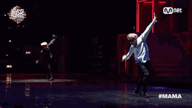 two dancers on a stage with a mnet logo on the bottom