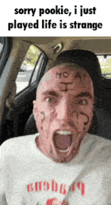 a man with a tattoo on his face is in a car with his mouth open