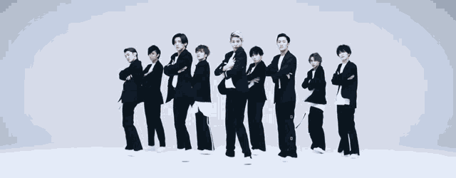 a group of men in suits are standing in a row with their arms crossed