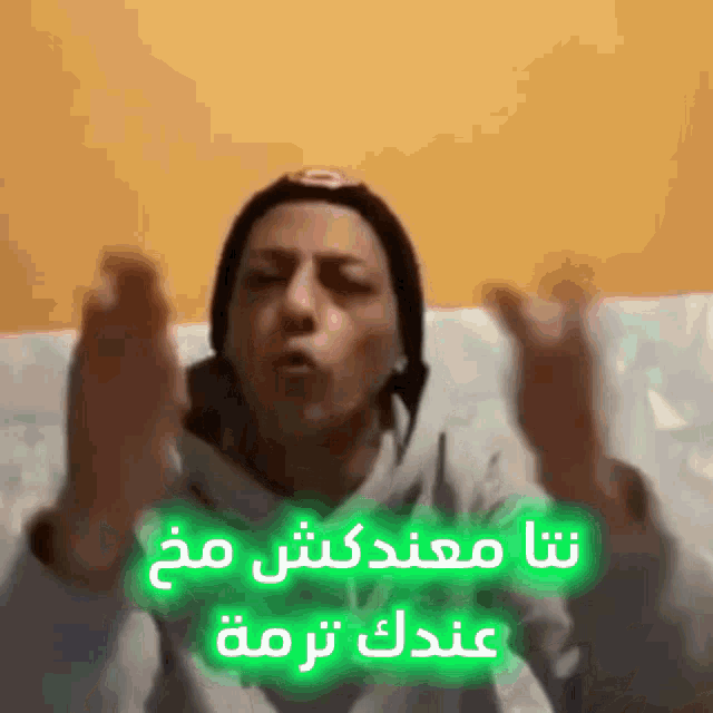 a person making a funny face with arabic writing on the bottom