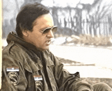 a man wearing sunglasses and a jacket with a patch that says ' army '