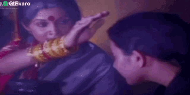 a woman is touching a man 's forehead with her hand .