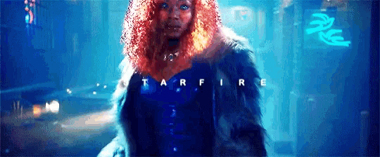 a woman with red hair is standing in front of a neon sign that says ' tarfire ' on it .