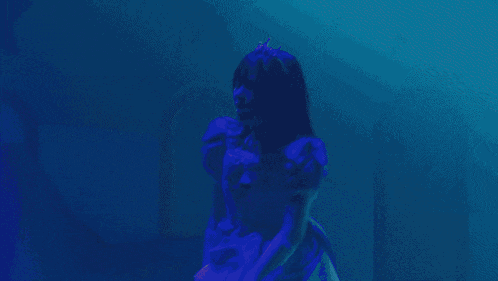a woman in a purple dress with a tiara on her head is dancing on a stage
