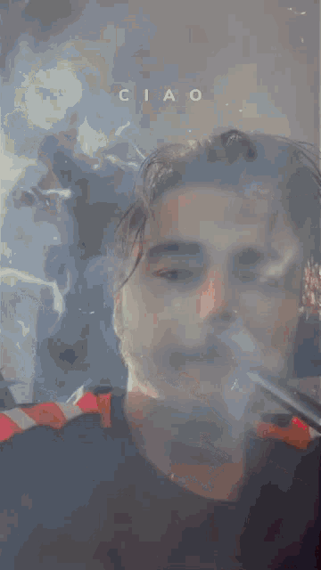 a man is smoking a cigarette and the word ciao is on the bottom of the image