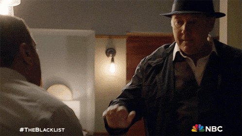 a man in a hat is shaking hands with another man with the nbc logo visible