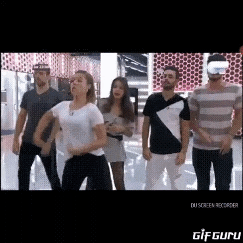 a group of people are standing next to each other and dancing .