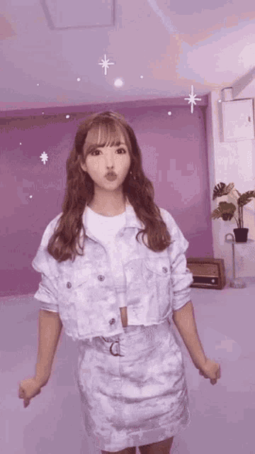 a woman is standing in front of a purple wall making a funny face .