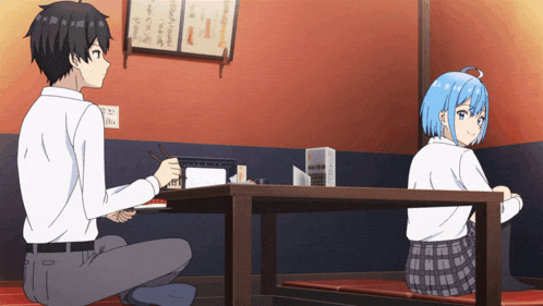 a boy and a girl are sitting at a table in a room