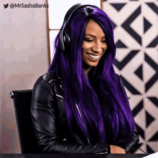 a woman with purple hair is wearing headphones and a black jacket