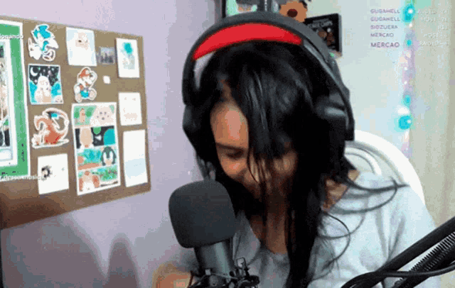 a woman wearing headphones talks into a microphone in front of a bulletin board that says mercado