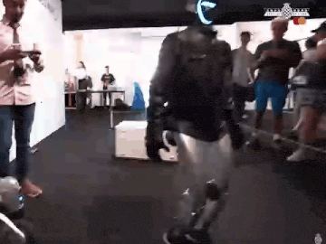 a man is standing in a room with a robot .