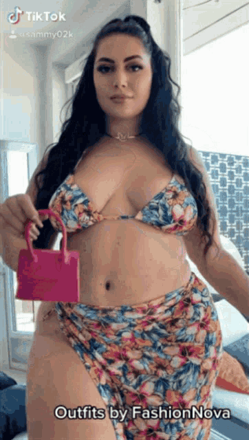 a woman is wearing a bikini and holding a pink purse ..