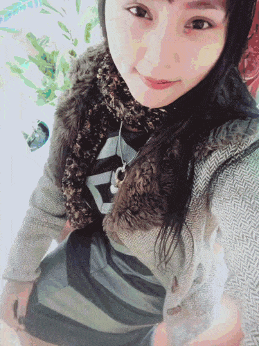 a woman taking a selfie with a necklace that says ' reebok ' on it