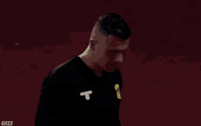 a man in a black shirt with the letter t on the front