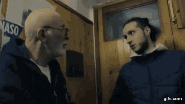 two men are standing next to each other in front of a door that says vaso